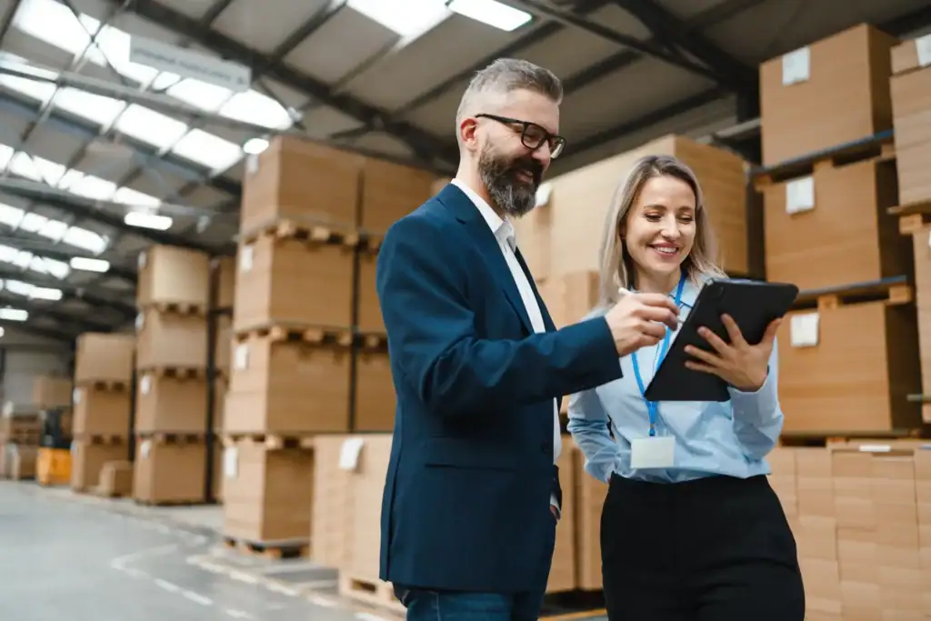 Hommes et femmes inspectant le stockage de cartons alvéolaire dans un entrepôt